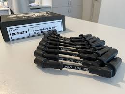 Set of black tools on a white surface with a branded box in the background.